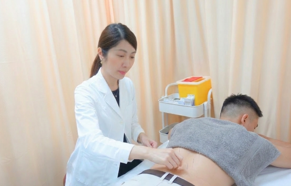方慶琳註冊中醫師於尖沙咀醫師坊診所內為男患者進行腰部針灸治療，專業止痛與體質調理。